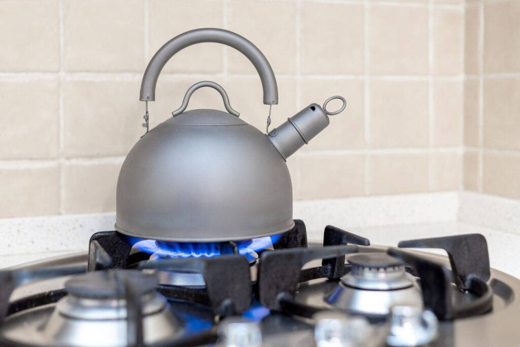 Metal kettle burning gas stove shallow depth field 611867 82