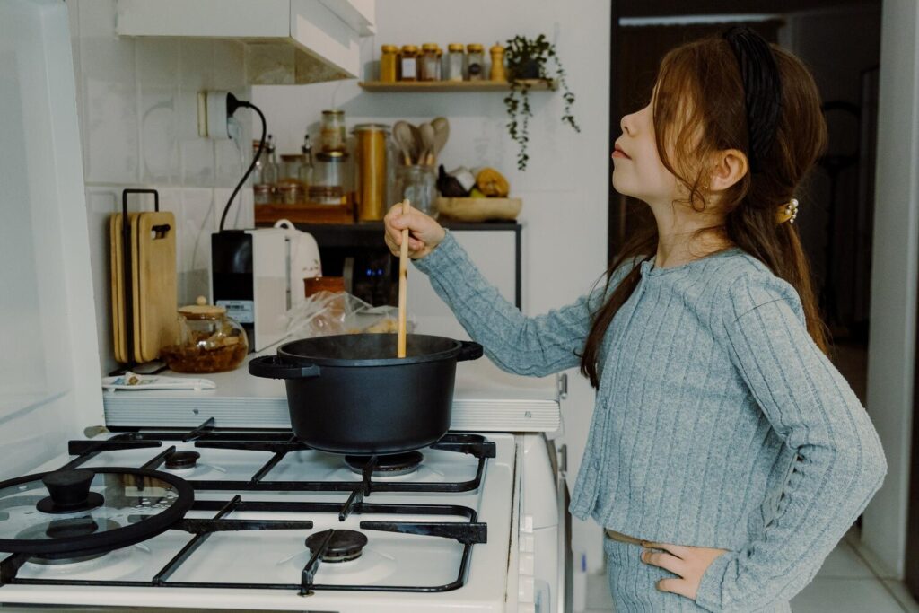 One child cooks his own pasta saucepan 432165 6370