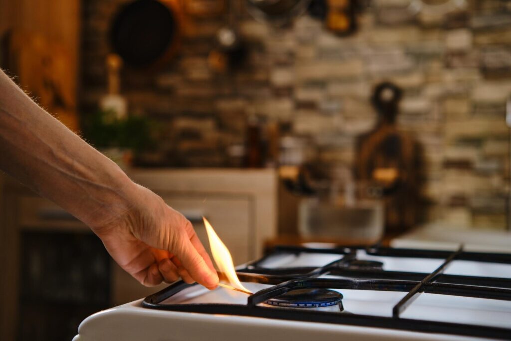 Unrecognizable man lights gas stove with match 105609 10786