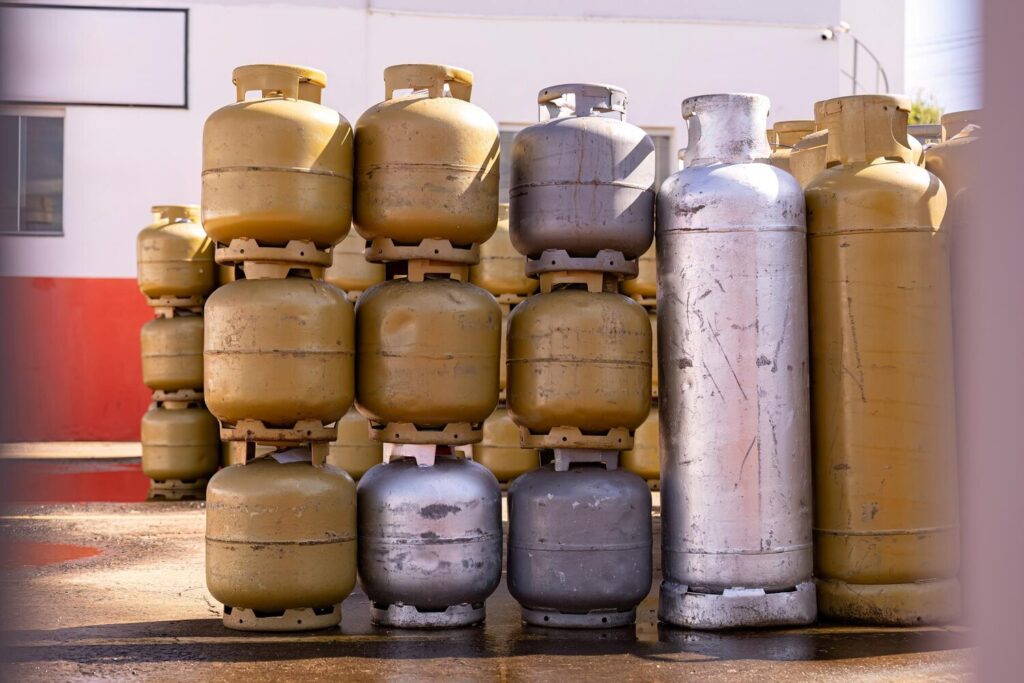Pile kitchen gas cylinders outside store 313877 15811
