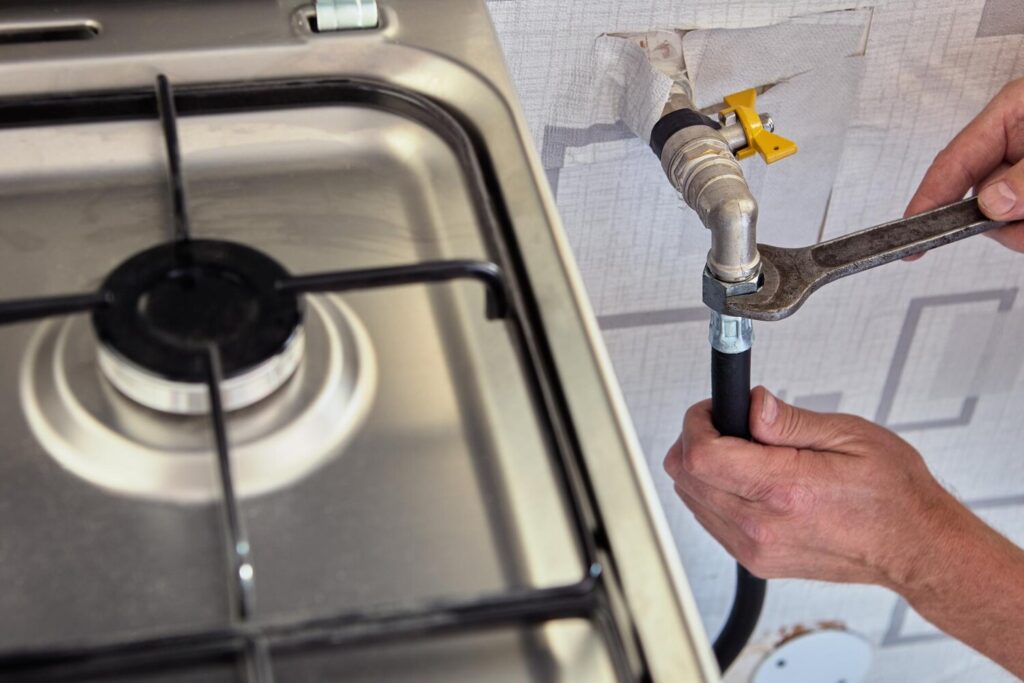 Gasman disconnects flexible hose from gas stove 351981 4571 Gasman disconnects flexible hose from gas stove 351981 4571